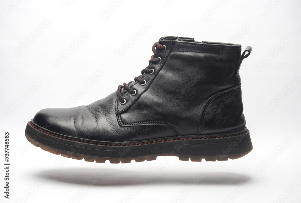 Black leather men's boot floating on a white background Black leather men's boot floating on a white background