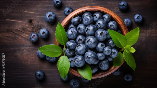 Fresh blueberry in a wooden bowl. Juicy and fresh blueberries with green leaves on a rustic table. Concept blueberry antioxidant for healthy eating and nutrition.
