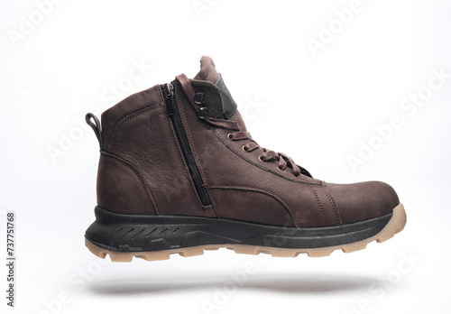 Brown leather boot floating on white background