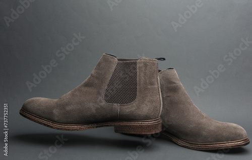 Men's suede boots floating on a dark gray background