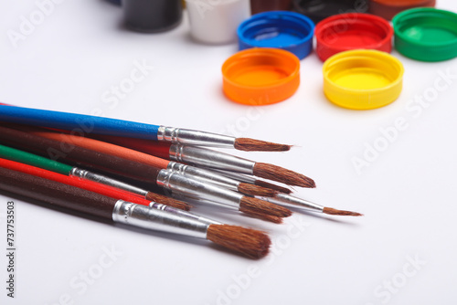 Set of gouache paints in bottles with brushes on a white background. Children's creativity