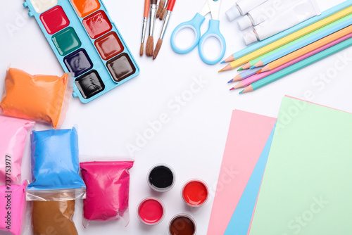 Children's creativity items on a white background. Paint, colored pencils, plasticine, brushes and scissors. Flat lay. Top view