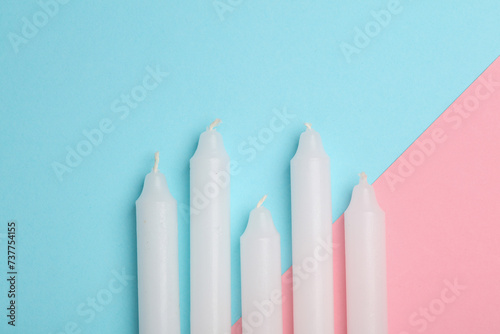 Set of wax candles on a blue pink background