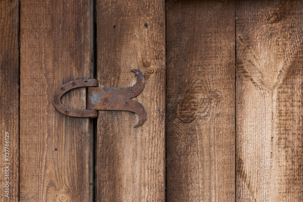 An old wooden barn door element features a textured surface and a rusty metal hinge. This vignette captures the rustic charm and timeless character of vintage craftsmanship.