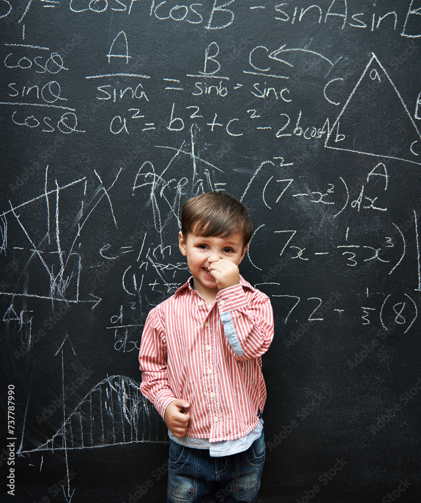 Child, boy and portrait with smile by blackboard with equations, numbers and education in classroom at school. Kid, student and happy for knowledge, learning and chalkboard with math and preschool