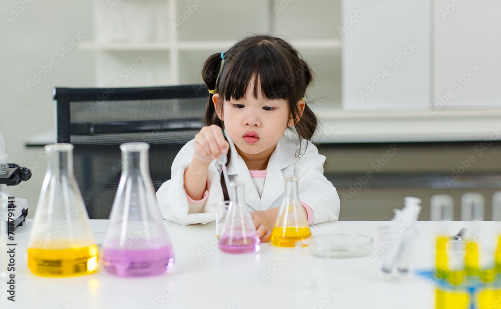 Asian little cute girl students in lab coat making test tube science experiments chemical laboratory in study room at school. Education research and development concept learning kids. Asian little cute girl students in lab coat making test tube science experiments chemical laboratory in study room at school. Education research and development concept learning kids.
