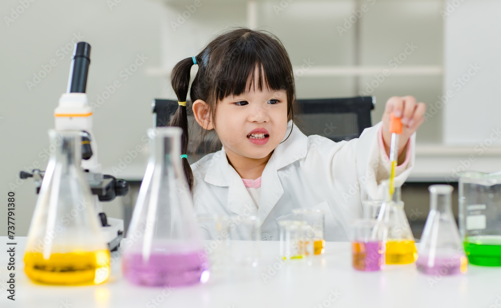 Asian little cute girl students in lab coat making test tube science experiments chemical laboratory in study room at school. Education research and development concept learning kids. Asian little cute girl students in lab coat making test tube science experiments chemical laboratory in study room at school. Education research and development concept learning kids.