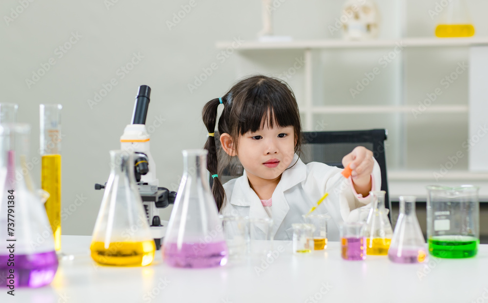 Asian little cute girl students in lab coat making test tube science experiments chemical laboratory in study room at school. Education research and development concept learning kids. Asian little cute girl students in lab coat making test tube science experiments chemical laboratory in study room at school. Education research and development concept learning kids.
