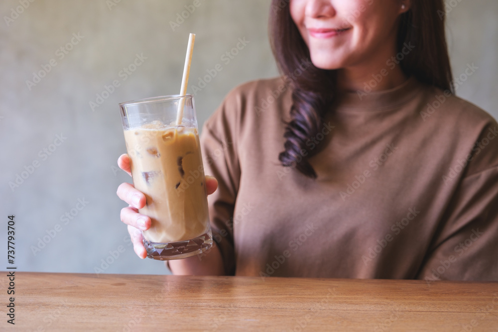 Φωτογραφία Closeup image of a young woman holding and looking at a glass of iced coffee