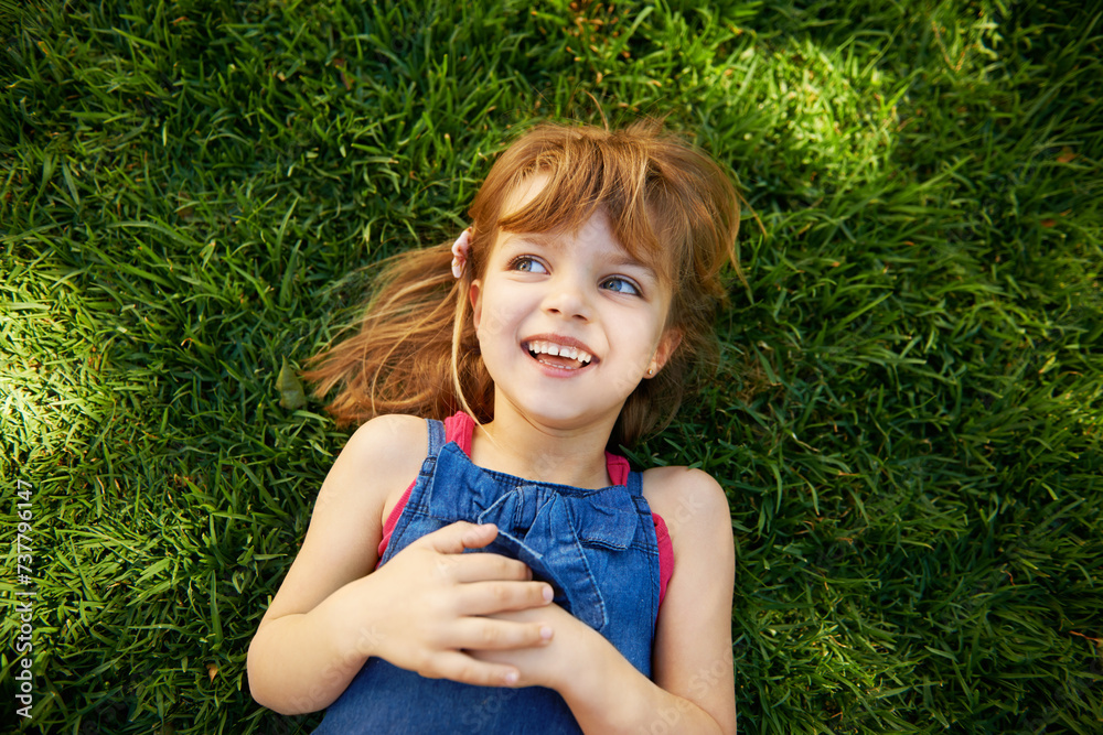 Child, grass and smile in backyard or above for relax holiday in countryside for summer vacation, nature or park. School kids, happy and California garden or environment for laugh, sunshine or meadow Child, grass and smile in backyard or above for relax holiday in countryside for summer vacation, nature or park. School kids, happy and California garden or environment for laugh, sunshine or meadow