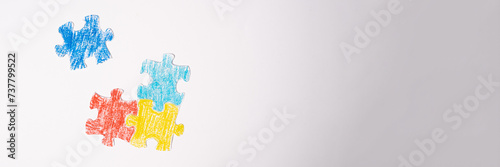Banner. Colorful puzzle on white background. Multi-colored heart as a symbol of World Autism Awareness Day. Flat lay photo