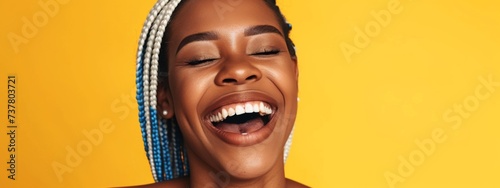 Portrait of laughing african american woman on yellow background