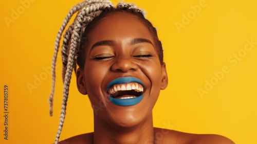 Portrait of laughing african american woman on yellow background