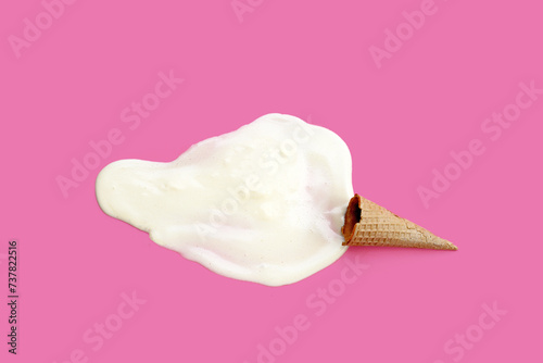 Melting ice cream with waffle cone on pink background.