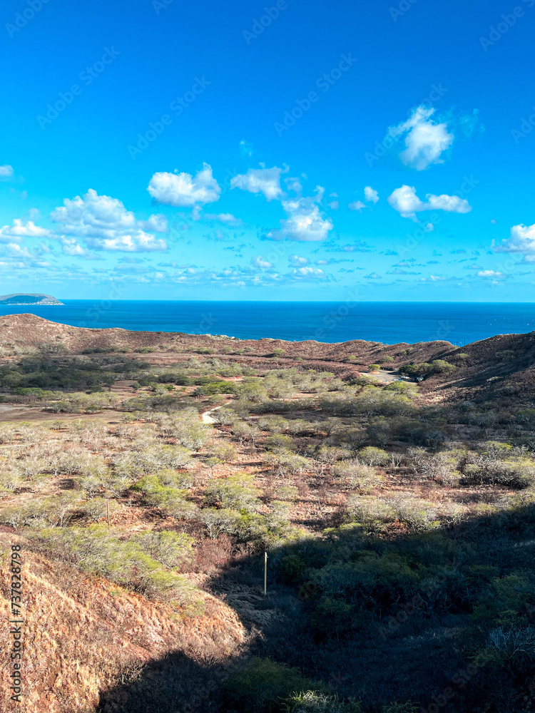 Hawaiian landscapes view from the top of the old volcano. The view from the top of Hawaiian volcano on the Oahu Island. Turquoise sky above island volcanic nature. Waikiki is way down underneath. Hawaiian landscapes view from the top of the old volcano. The view from the top of Hawaiian volcano on the Oahu Island. Turquoise sky above island volcanic nature. Waikiki is way down underneath.