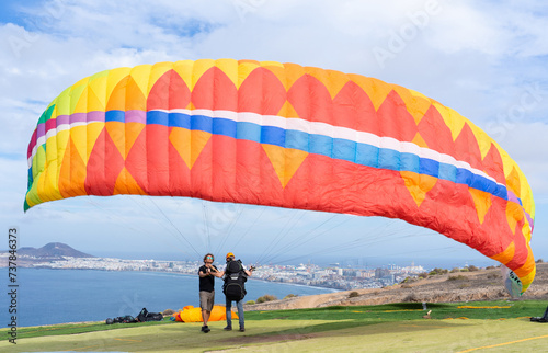 Paraglider learning to fly a paraglider with the help of an instructor