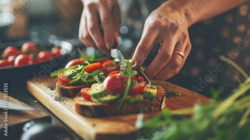 Close-up of hands preparing a healthy organic avocado toast, topped with cherry tomatoes