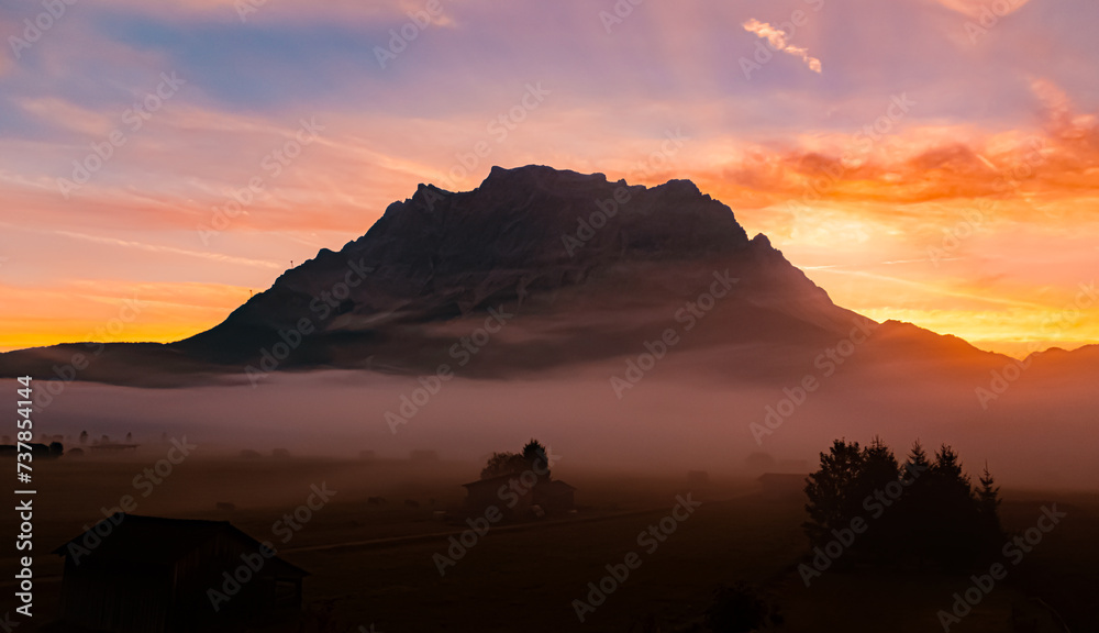 Foggy alpine sunrise view with Mount Zugspitze at Lermoos, Reutte, Tyrol, Austria