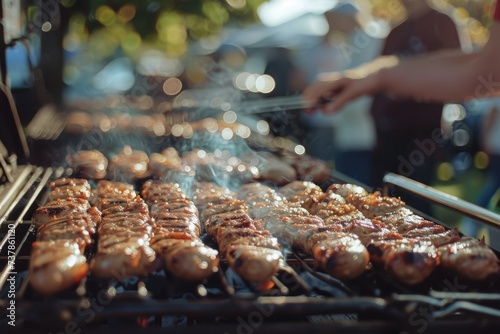 Sausages grilling on barbecue with smoke. Close-up outdoor cooking.