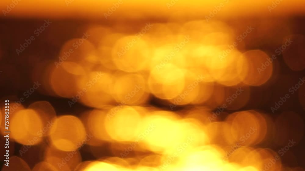 Blurred golden sea at sunset. The sun reflects and sparkles on the waves with bokeh, illuminating the golden sea. Holiday recreation concept. Abstract nautical summer ocean sunset nature background. Blurred golden sea at sunset. The sun reflects and sparkles on the waves with bokeh, illuminating the golden sea. Holiday recreation concept. Abstract nautical summer ocean sunset nature background.
