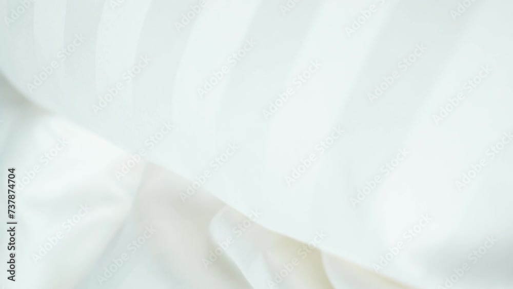 Beautiful moving background of light milky color, waves on fabric