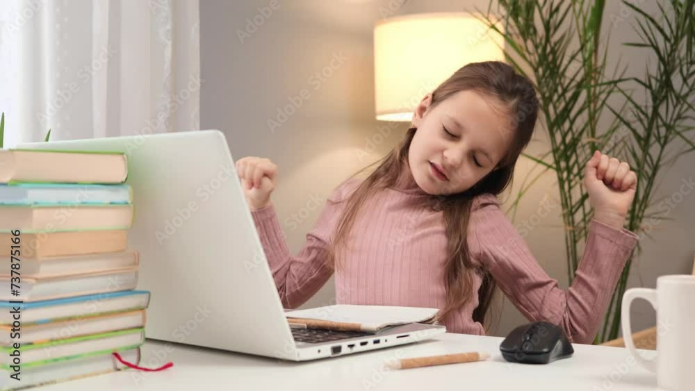 Virtual classroom interaction. E-learning environment for kids. Serious Caucasian little brown haired girl using laptop studying online at home writing down information with focused expression Virtual classroom interaction. E-learning environment for kids. Serious Caucasian little brown haired girl using laptop studying online at home writing down information with focused expression