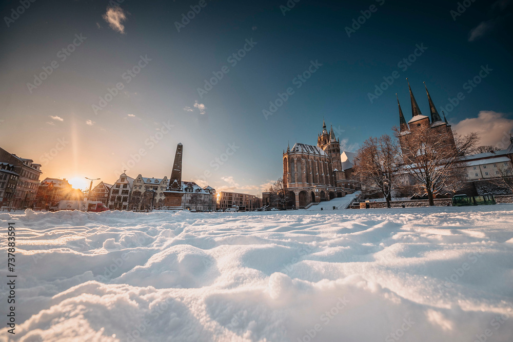 Der Erfurter Domplatz ist bedeckt von Schnee. In den frühen morgen Stunden, während des Sonnenaufgangs glänzte der Dom und St. Severi in strahlendem Licht, erhaben auf dem Domberg.