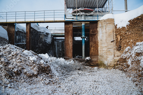 An old dam in a deplorable condition, a destroyed dam, restoration work, repair of watercourse channels. photo