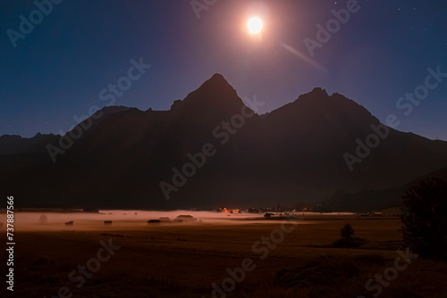 Foggy alpine long exposure night view with Mount Sonnenspitze and the moon at Lermoos  Reutte  Tyrol  Austria