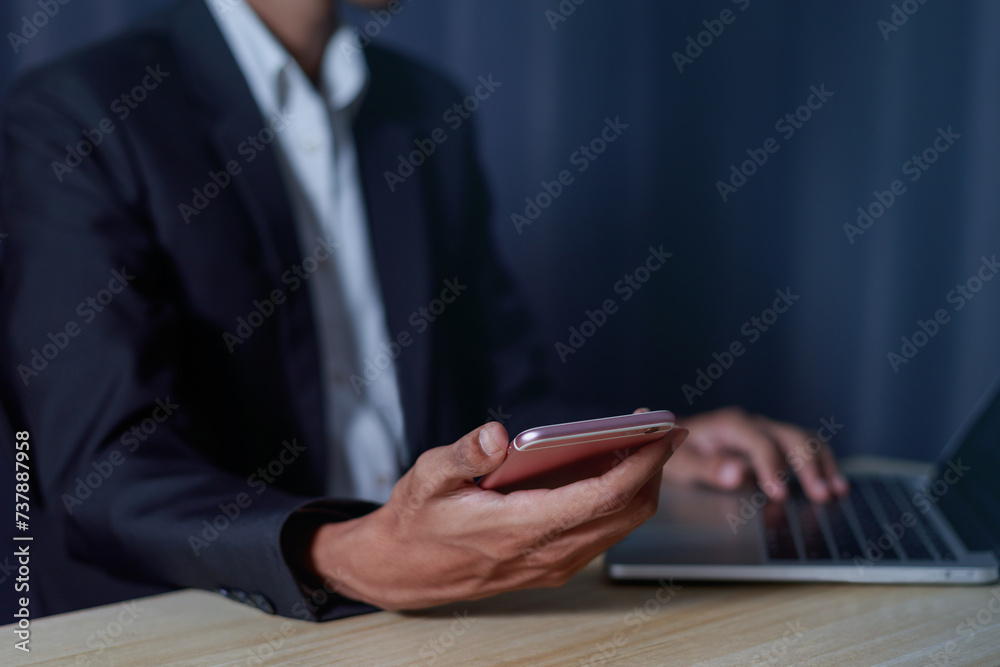 Businessman's hands holding a mobile phone with a laptop computer working from home. business success concept Businessman's hands holding a mobile phone with a laptop computer working from home. business success concept
