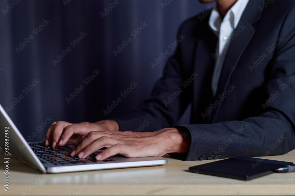 Obraz premium Businessman using laptop and typing on laptop computer keyboard in business success concept..