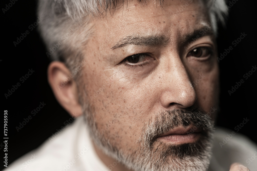 Obraz premium グレイヘアの髭のあるミドル男性の顔/スタジオ撮影黒背景