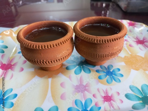 Green tea in clay cup, hot tea clay payali in winter,Desi mud cup of tea in winter Morning, 
Pair of mud cups of tea,Hot tea in winter,close up view of Indian two Mud tea cup in the color background  photo