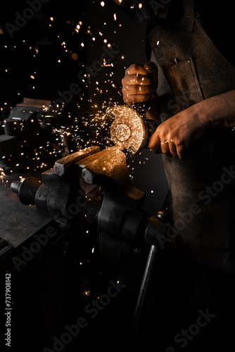 Blacksmith using a grinder that generates sparks