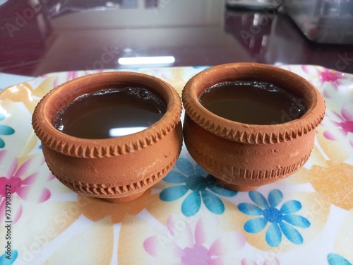 Green tea in clay cup, hot tea clay payali in winter,Desi mud cup of tea in winter Morning, 
Pair of mud cups of tea,Hot tea in winter,close up view of Indian two Mud tea cup in the color background  photo