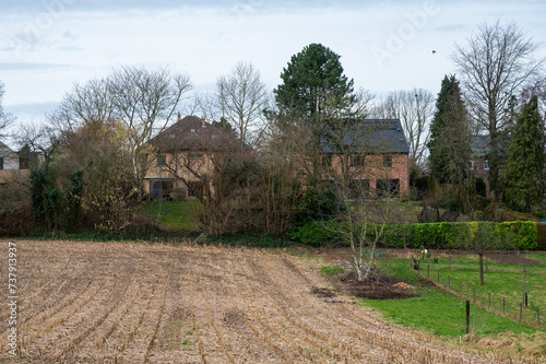 Harvested wheat fields and meadows with farmhouses around Herent, Brabant, Belgium photo