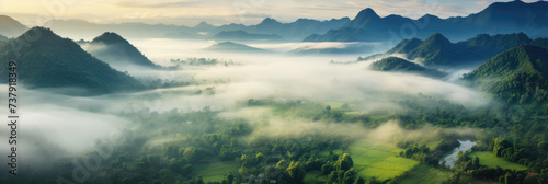 A panoramic view of misty mountains and lush green valleys under a soft morning light. 