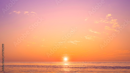 Romantic sunset sky background over sea with golden fluffy cloud on idyllic orange evening sky and sunlight reflection on water surface, beautiful nature tranquil seascape in minimal style