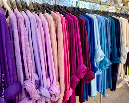 Colourful jumpers on a rail in a market