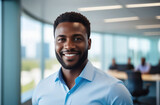 Portrait handsome office executive standing in contemporary start-up coworking open space office. Black man 30-35 yo manager smiling, looking at camera. Teamwork, business people. Blurred background