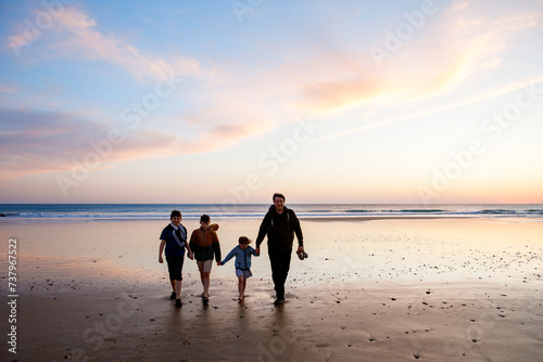 Portrait silhouettes of three children and dad happy kids with father on beach at sunset. happy family, Man, two school boys and one little preschool girl. Siblings having fun together. Bonding photo