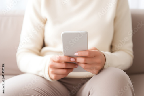 A woman holds a mobile phone in her hands.