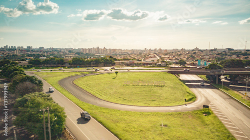 Aerial drone view of the entrance to the city of Sao Jose do Rio Preto with the sign in the foreground  the highway viaduct and the city center buildings in the background on a sunny day