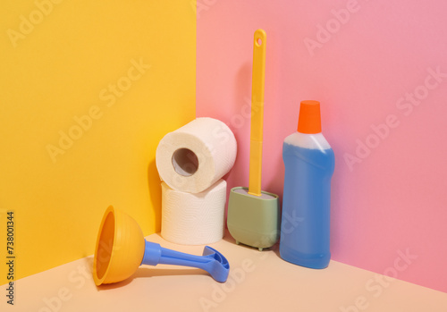 Cleaning products and colorful composition of toiletries. Toilet paper, plunger, toilet brush and detergent.