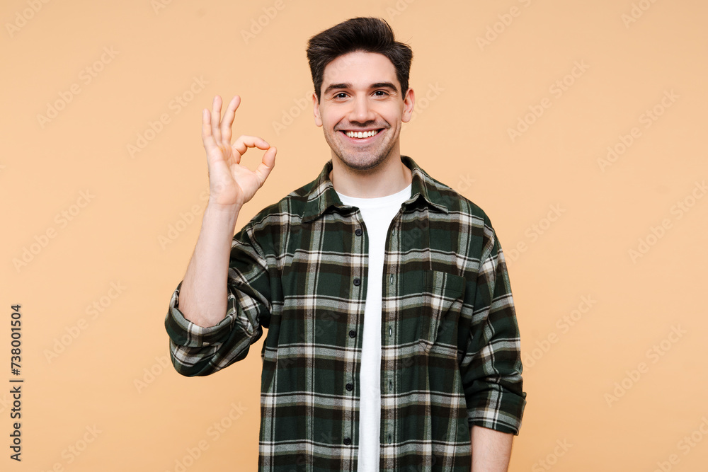 Fototapeta premium Portrait of attractive stylish man wearing stylish hipster outfit showing ok sign