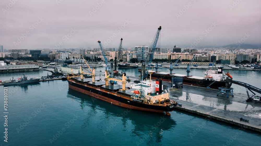 Breathtaking aerial perspective of a massive cargo ship docked at vibrant port 