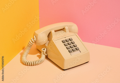 Beige vintage phone with gray buttons on the desk. Idea of communication.