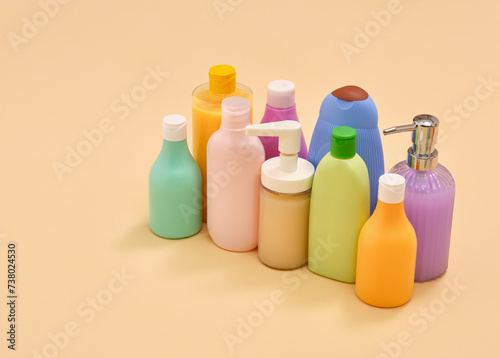 Hygiene accessories in home bathroom. Shower gels and shampoos in colored bottles. Copy space for text.