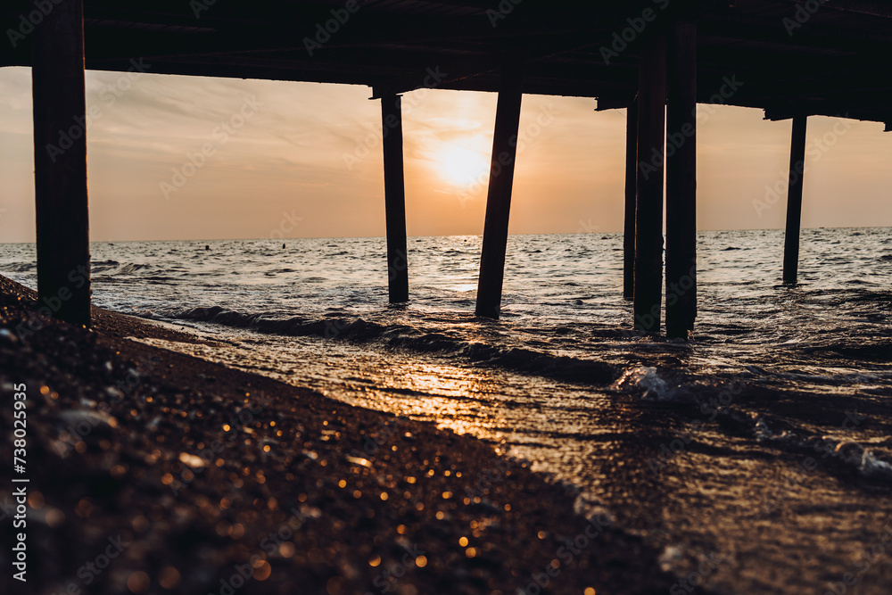beautiful evening landscape on the sea. sunset of the setting sun. the sun disappeared behind the horizon of the sea. sea view through the pillars of the embankment.Turkey Mediterranean Sea