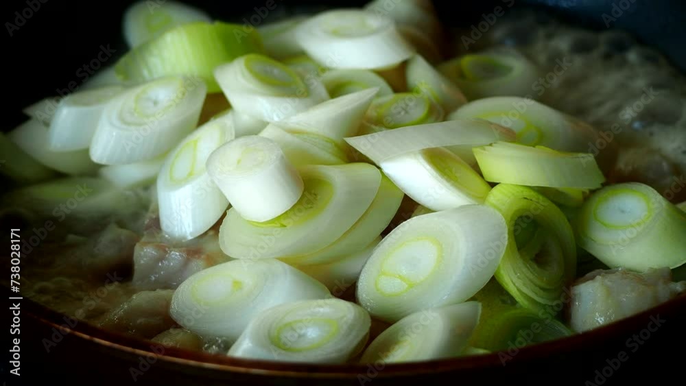 Frying Japanese spring onions with chopped fishes in pan, in door Chiangmai Thailand.